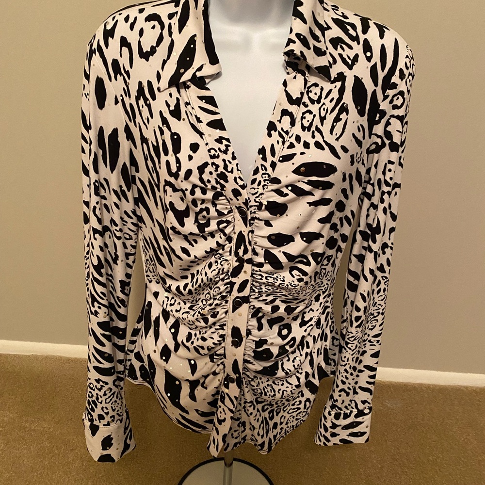 Cache top size M with stretch and has snap front and at cuffs.